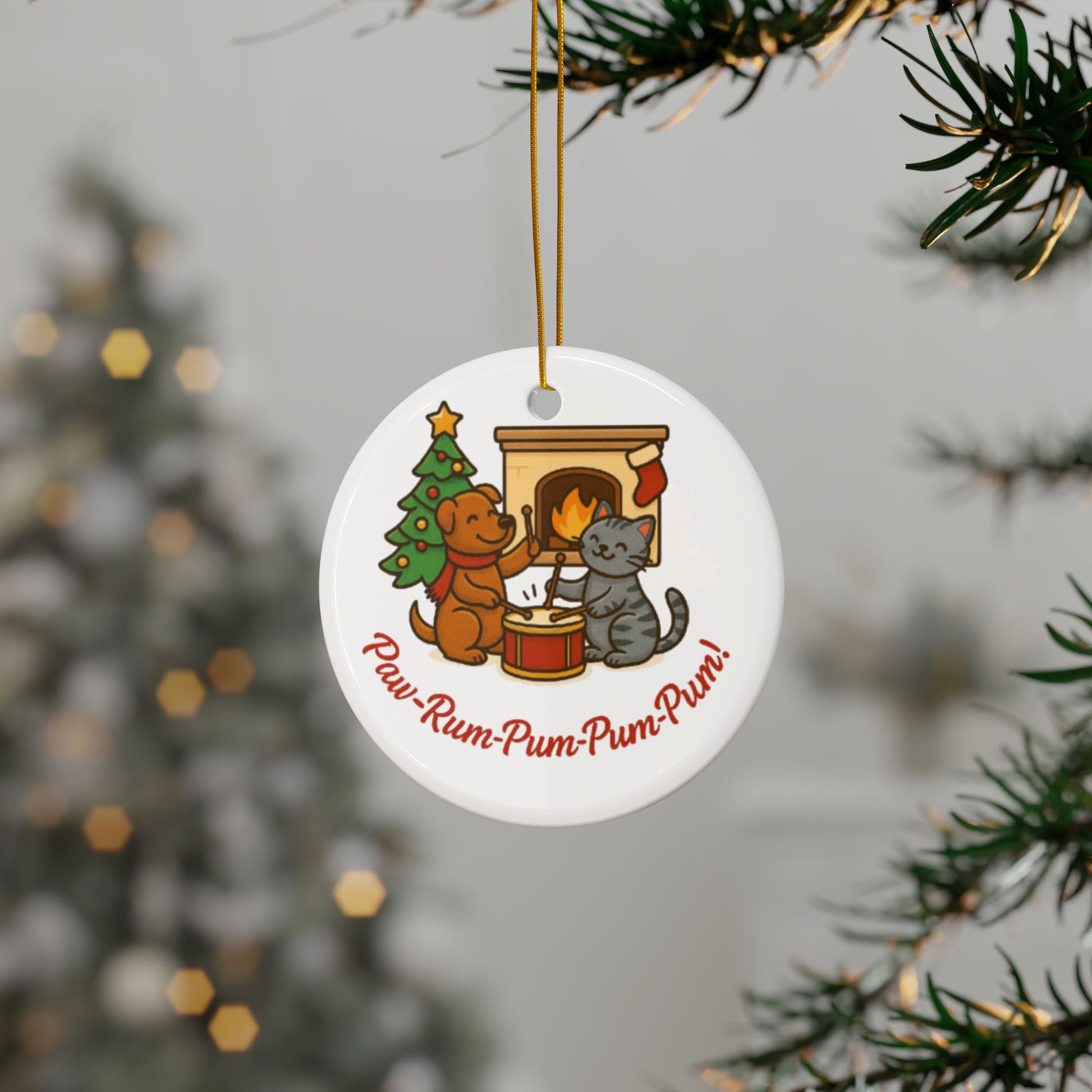Circular Christmas ornament with dog and cat design hanging from a tree.