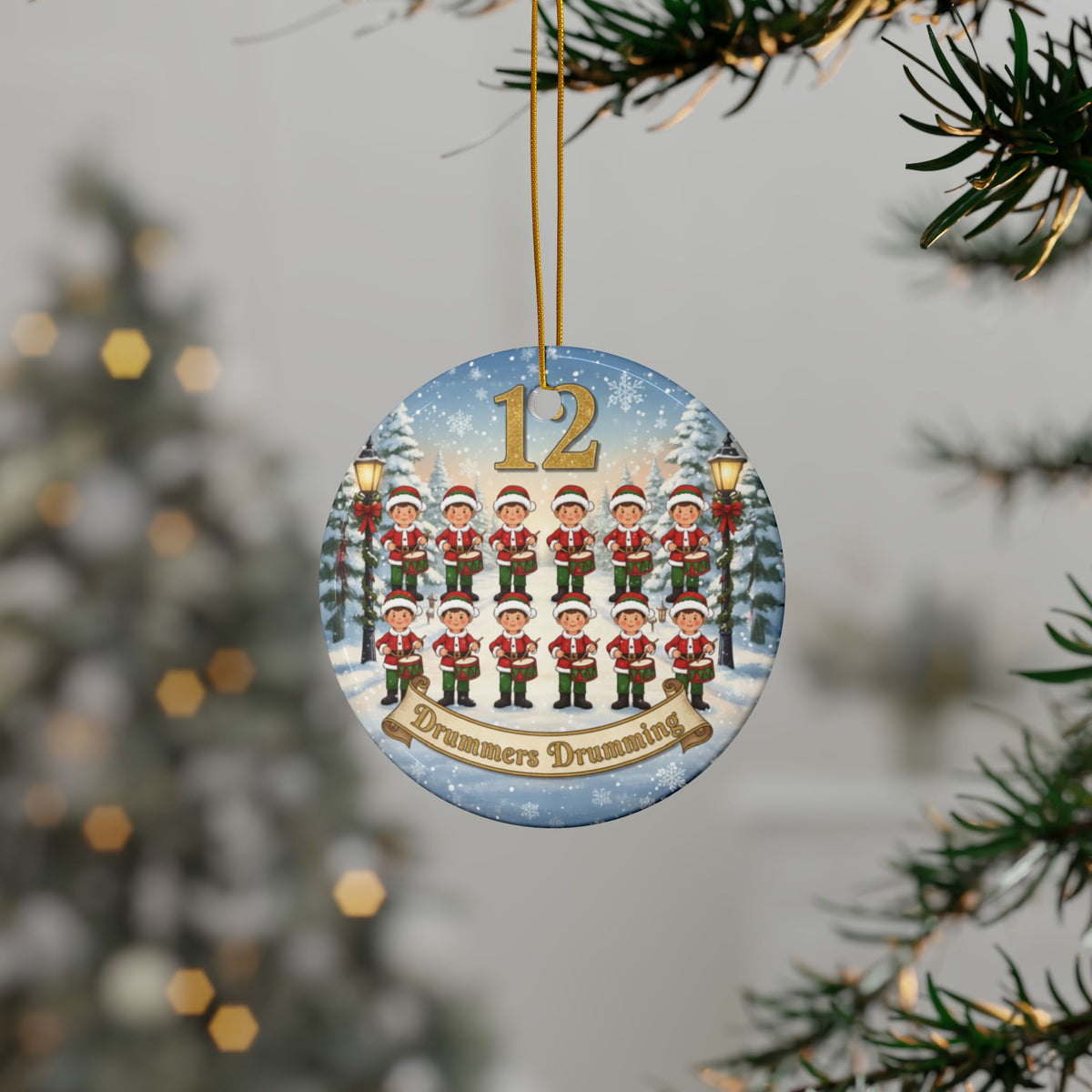 Circular Christmas ornament with '12 Days of Christmas' design, featuring 12 drummers drumming, hanging on a tree.