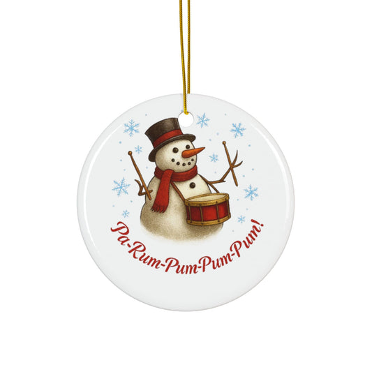 Round ceramic ornament with a snowman playing a drum and text 'Pu-Rum-Pum-Pum!' on a white background.