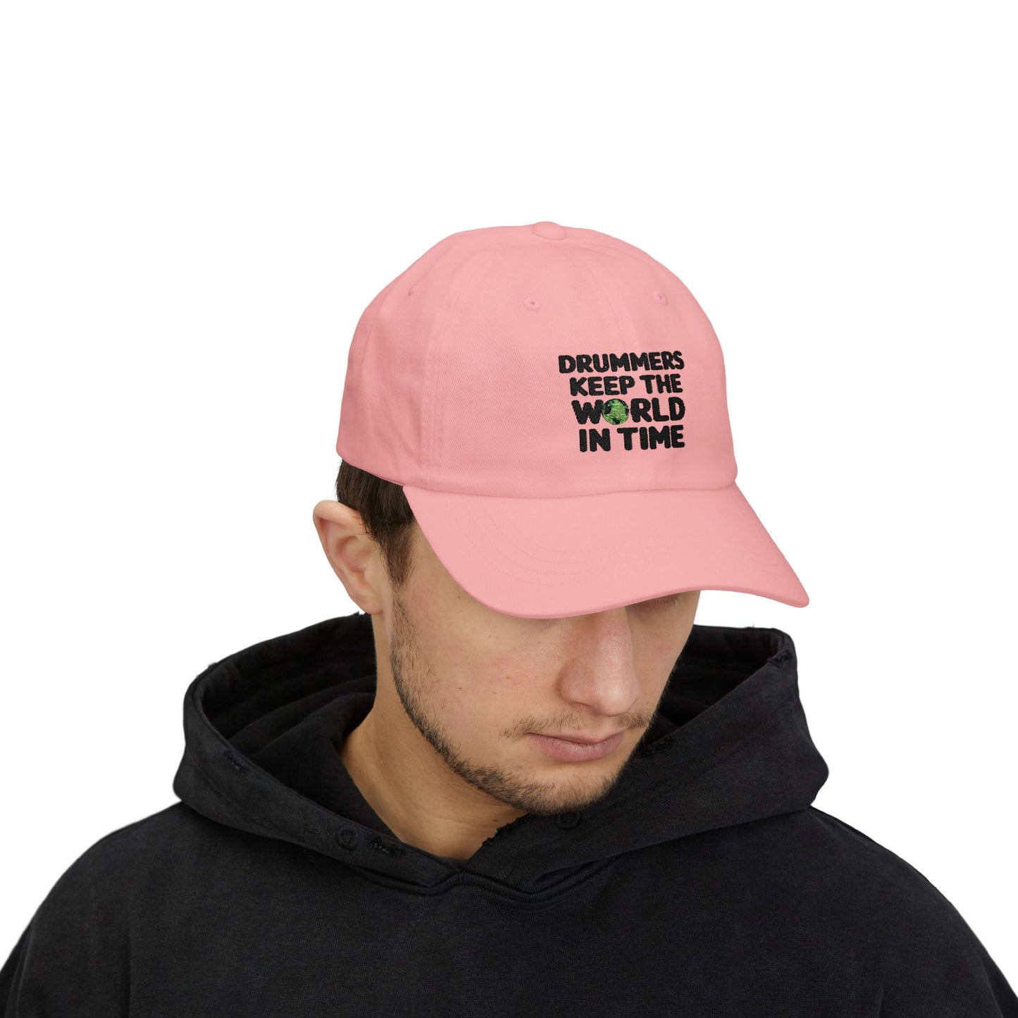 Person wearing a pink cap with text 'Drummers Keep the World in Time'.
